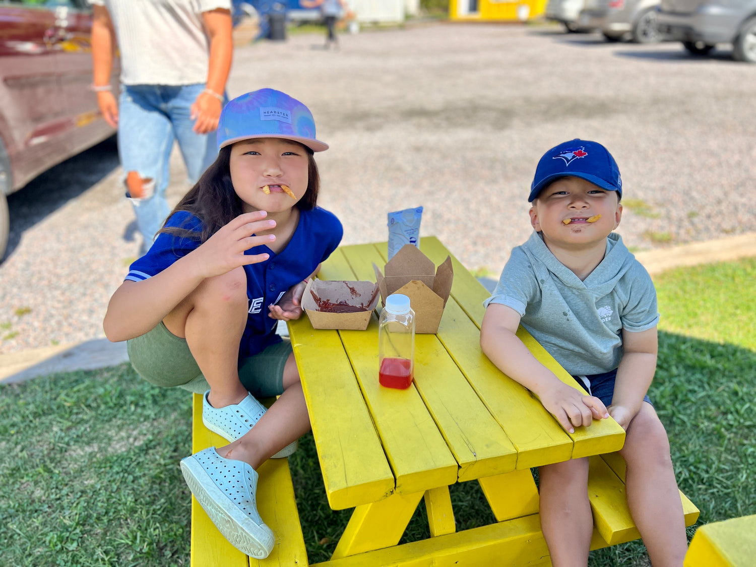 Kids eating french fries on a picnic table, before Tallow & Fries